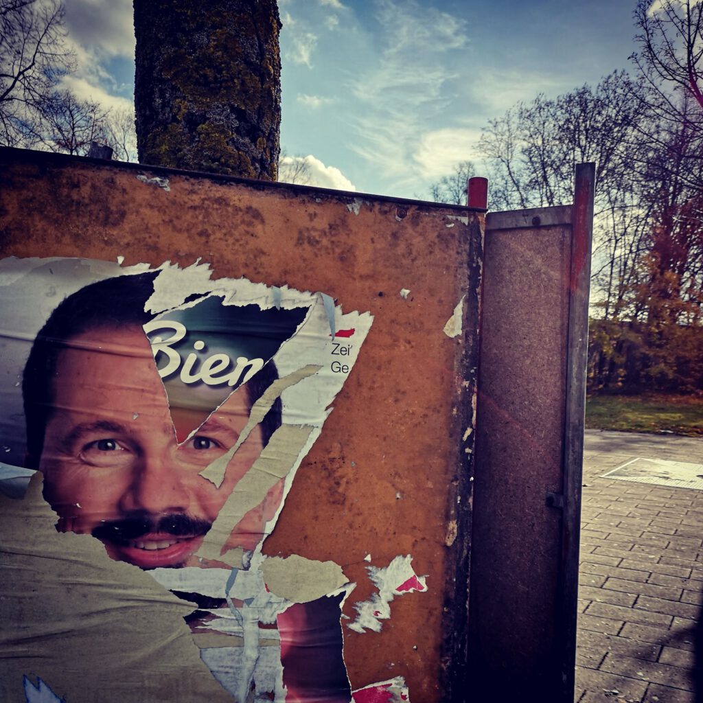 Auf einem Plakatständer sind Teile des Gesichts von Bernhard Goodwin auf Resten eines Wahlplakats zu sehen.